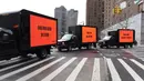 Tiga mobil box yang membawa billboard yang bertema kepedulian untuk Suriah turun ke jalan mengelilingi gedung Perserikatan Bangsa-Bangsa (PBB) di New York (22/2). (AFP Photo/Timothy A. Clary)