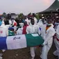 Petugas kesehatan membawa peti mati selama pemakaman 75 korban di Freetown pada 8 November 2021 di ibu kota Sierra Leone [Saidu Bah/ AFP].