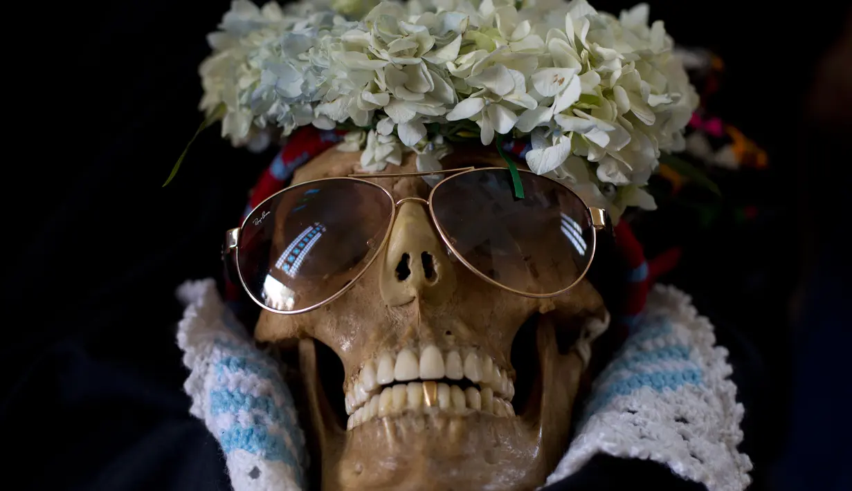 Tengkorak manusia dihias dengan bunga dan dipakaikan kacamata saat Festival Natitas di La Paz, Bolivia (8/11). Ritual ini digelar seminggu setelah Hari Mati di Bolivia. (AP Photo/Juan Karita)