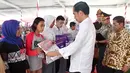 Presiden Jokowi menyerahkan kartu Program Keluarga Harapan (PKH) secara simbolis kepada perwakilan warga di SMA Negeri 1 Palembang, Sumatra Selatan (22/1). (Liputan6.com/Pool/Biro Setpres)