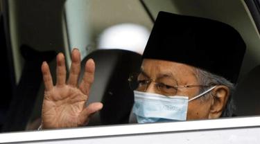Mantan Perdana Menteri Malaysia Mahathir Mohamad, mengenakan masker, melambai saat meninggalkan Istana Nasional setelah bertemu dengan raja di Kuala Lumpur, Malaysia, Kamis, 10 Juni 2021. (AP/Vincent Thian)
