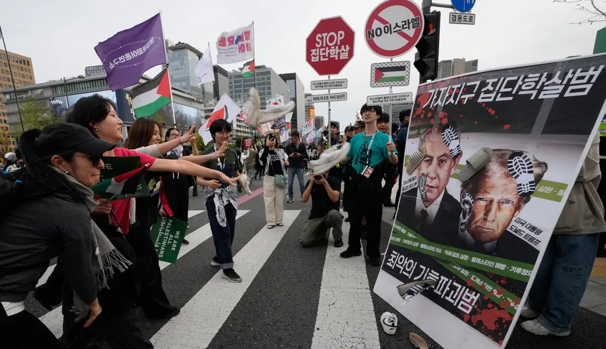 Warga yang menyatakan solidaritas terhadap Palestina melempar sepatu ke arah papan bergambar Presiden Amerika Serikat Donald Trump dan Perdana Menteri Israel Benjamin Netanyahu saat berjalan menuju Kedutaan Besar AS dalam aksi yang mengecam tindakan militer AS dan Israel di Gaza, di Seoul, Korea Selatan, Sabtu (3/10/2026). Aksi tersebut merupakan bagian dari rangkaian unjuk rasa yang menyuarakan dukungan terhadap Palestina dan menyerukan penghentian konflik di Gaza. (AP Photo/Ahn Young-joon)
