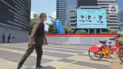 Warga berjalan dekat proyek pembangunan Tugu Sepeda di  kawasan Jenderal Sudirman, Jakarta, Rabu (22/9/2021). Dinas Perhubungan DKI Jakarta memastikan pembangunan Tugu Sepeda masih berlanjut, dan pembangunnya hingga saat ini telah mencapai 90 persen. (Liputan6.com/Herman Zakharia)