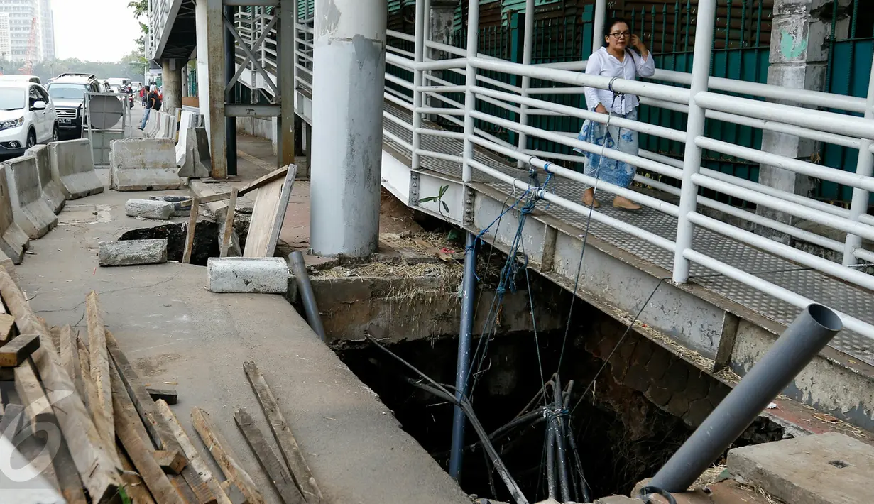 Jembatan Penyeberangan Orang (JPO) Polda Metro Jaya yang terhubung dengan halte Transjakarta, Jalan Jenderal Sudirman untuk sementara ditutup, Rabu (11/11/2015). Penutupan dilakukan karena jalan di dekat tiang JPO amblas. (Liputan6.com/Yoppy Renato)