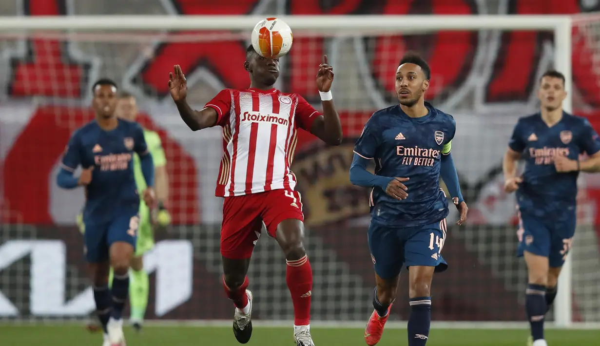 Gelandang Olympiakos, Mady Camara mengontrol bola disamping striker Arsenal, Pierre-Emerick Aubameyang pada leg pertama babak 16 besar Liga Europa di stadion Georgios Karaiskakis, Athena, Jumat (12/3/2021).Arsenal dapat melaju ke perempatfinal meski kalah 0-2. (AP Photo/Thanassis Stavrakis)