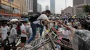 Seorang wanita memanjat paga saat bentrok dengan polisi anti huru hara di luar gedung Dewan Legislatif, Hong Kong, Rabu (12/6/2019). Polisi Hong Kong telah menggunakan gas air mata ke arah ribuan demonstran yang menentang RUU ekstradisi yang sangat kontroversial. (AP Photo/ Kin Cheung)