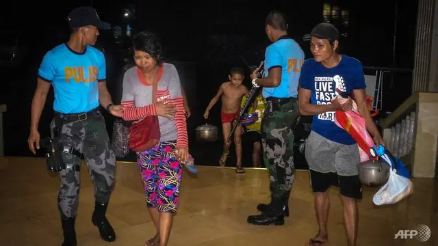 Pihak polisi membantu korban bencana di tempat evakuasi.