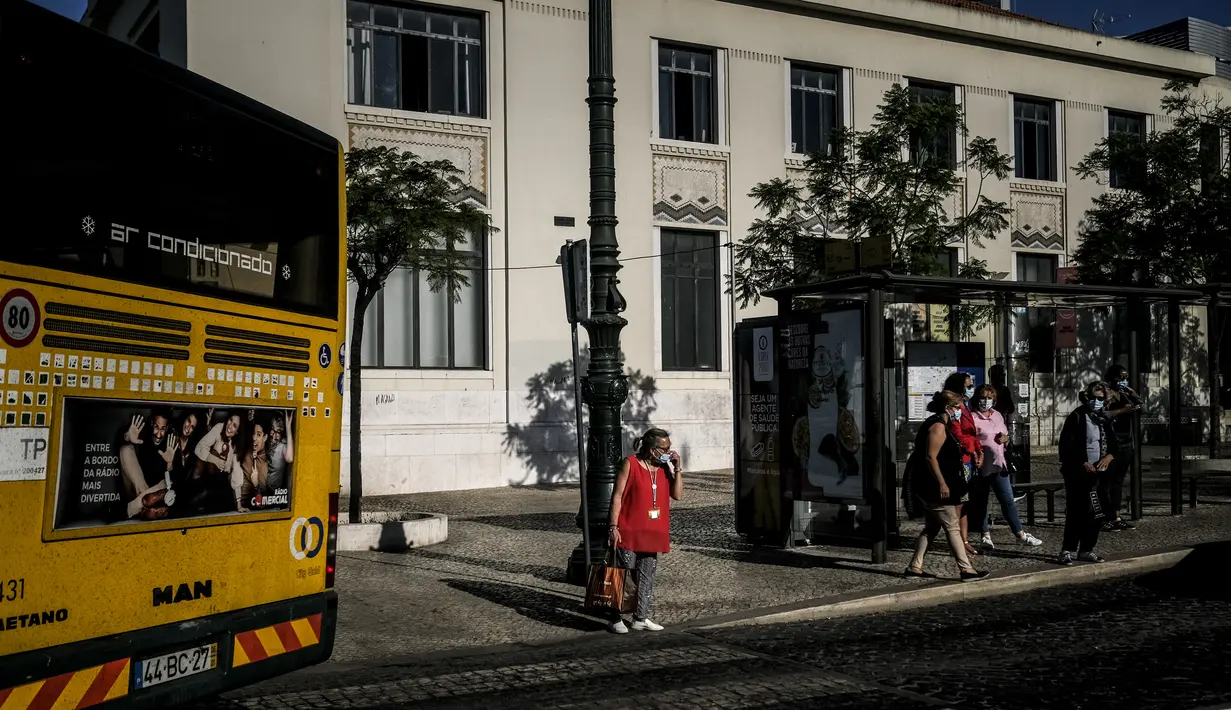 Seorang wanita menunggu untuk menyeberang jalan dekat halte bus di Cais do Sodre di Lisbon (14/7/2021). Pemerintah berusaha untuk mengendalikan kebangkitan infeksi virus corona, karena varian Delta yang lebih menular. (AFP/Patricia De Melo Moreira)