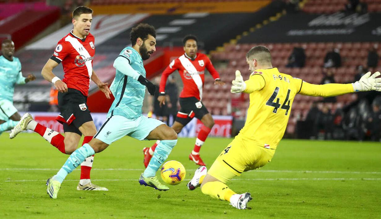 Penyerang Liverpool, Mohamed Salah berusaha melewati kiper Southampton, Fraser Forster, pada laga Liga Inggris di Stadion St Mary's, Selasa (05/01/2021). Liverpool takluk 1-0 dari Southampton. (AP Photo/Michael Steele,Pool)