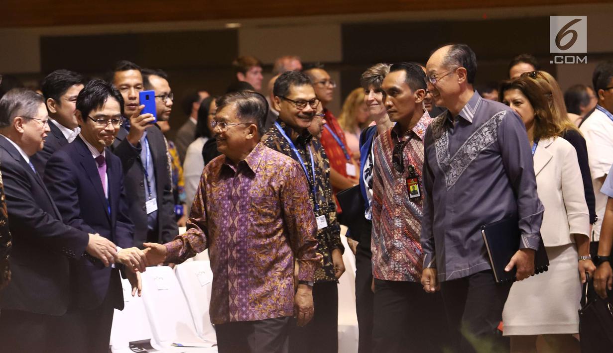 Wakil Presiden RI Jusuf Kalla bersalaman dengan peserta saat tiba menghadiri Dialog Tingkat Tinggi tentang Pembiayaan dan Asuransi Risiko Bencana selama acara IMF-World Bank Group 2018, Bali, Rabu (10/10). (Liputan6.com/Angga Yuniar)