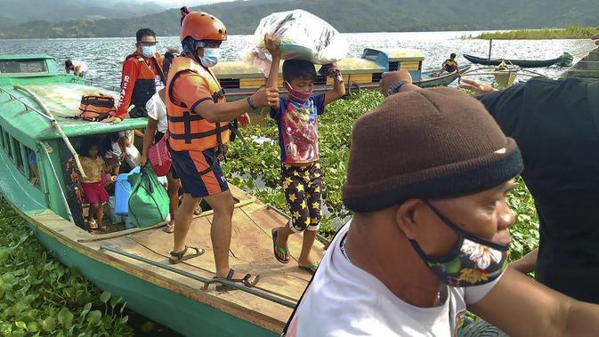 Keluarga dievakuasi ke tempat yang lebih aman di provinsi Camarines Sur, Filipina (31/10/2020). Keluarga yang tinggal di dekat kota-kota pesisir mulai pindah ke pusat-pusat evakuasi saat topan kuat mendekati negara itu. (Philippine Coast Guard via AP)