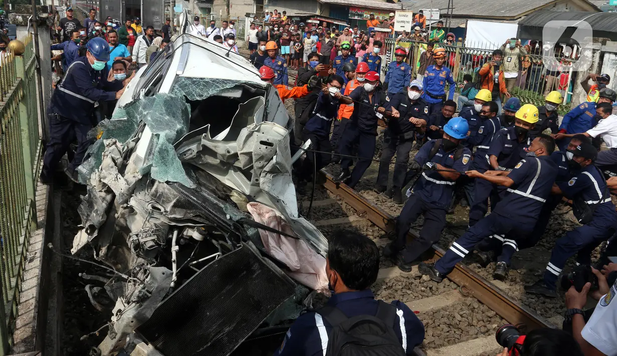 Petugas mengevakuasi mobil Honda Mobilio yang tertabrak KRL Commuterline KA 1077 (Bogor-Jakarta Kota) di kawasan Rawageni, Ratu Jaya, Cipayung, Depok, Jawa Barat, Rabu (20/4/2022). Terganggunya perjalanan KRL karena kereta harus melaju di satu jalur secara bergantian. (merdeka.com/Arie Basuki)