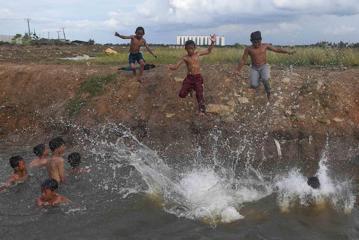 FOTO: Keceriaan Anak-Anak Bermain Pada Saluran Air di Tanjung Pasir
