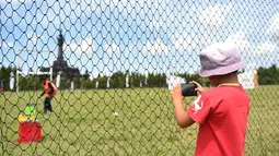 Seorang anak mengambil gambar dengan telepon selularnya sebelum dimulainya acara Piala Dunia Drone Racing di Denpasar di pulau resor Indonesia Bali (7/4). (AFP Photo/Sonny Tumbelaka)