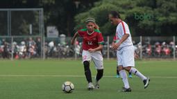 Pemain Timnas Wanita Indonesia, Zahra Musdalifah (kiri) berusaha menutup gerakan pemain Legenda Indonesia pada laga uji coba di Lapangan ABC Senayan, Jakarta, Kamis (5/4/2018). Timnas Wanita Indonesia menang 3-2. (Bola.com/Nick Hanoatubun)