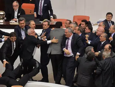 Anggota parlemen partai oposisi (CHP) dan partai berkuasa AK terlibat adu jotos saat pembahasan undang-undang di Ankara, Turki, Kamis (19/2). Kericuhan terjadi setelah perdebatan sengit tentang UU untuk meningkatkan kekuatan polisi. (AFP PHOTO/ADEM ALTAN)