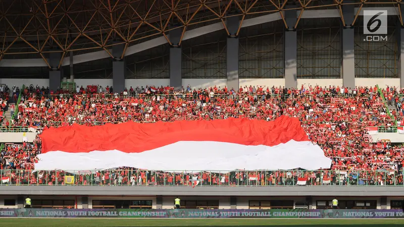 Suporter Timnas Indonesia membentangkan bendera raksasa sebelum laga melawan Fiji di Stadion Patriot, Bekasi, Sabtu (9/2/2017). Laga berakhir imbang 0-0. (Liputan6.com/Helmi Fithriansyah)