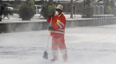 Petugas memakai masker membersihkan jalan yang tertutup abu setelah letusan awal gunung berapi Popocatepetl di Puebla, Meksiko, (18/4). Pemerintah Meksiko mengatakan gunung Popocatepetl menyemburkan abu vulkanis setinggi 3 km. (REUTERS/Imelda Medina)