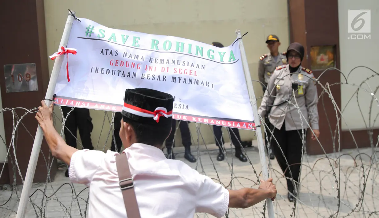 Massa Aliansi Anak Bangsa untuk Kemanusiaan memasang spanduk sebagai tanda penyegelan di depan Kedubes Myanmar, Jakarta, Selasa (5/9). Mereka menggelar aksi demonstrasi dan doa bersama dalam rangka bela Muslim Rohingya. (Liputan6.com/Faizal Fanani)