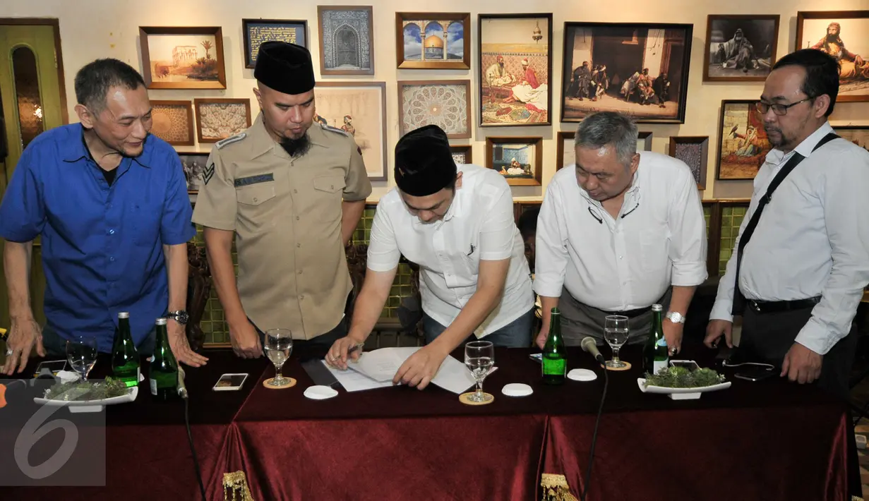 Farhat Abbas disaksikan Ahmad Dhani menandatangani surat perjanjian dalam sebuah pertemuan di Jakarta, Selasa (20/12). Surat itu berisi penunjukkan Farhat Abbas sebagai kuasa hukum Ahmad Dhani dalam kasus dugaan makar. (Liputan6.com/Yoppy Renato)