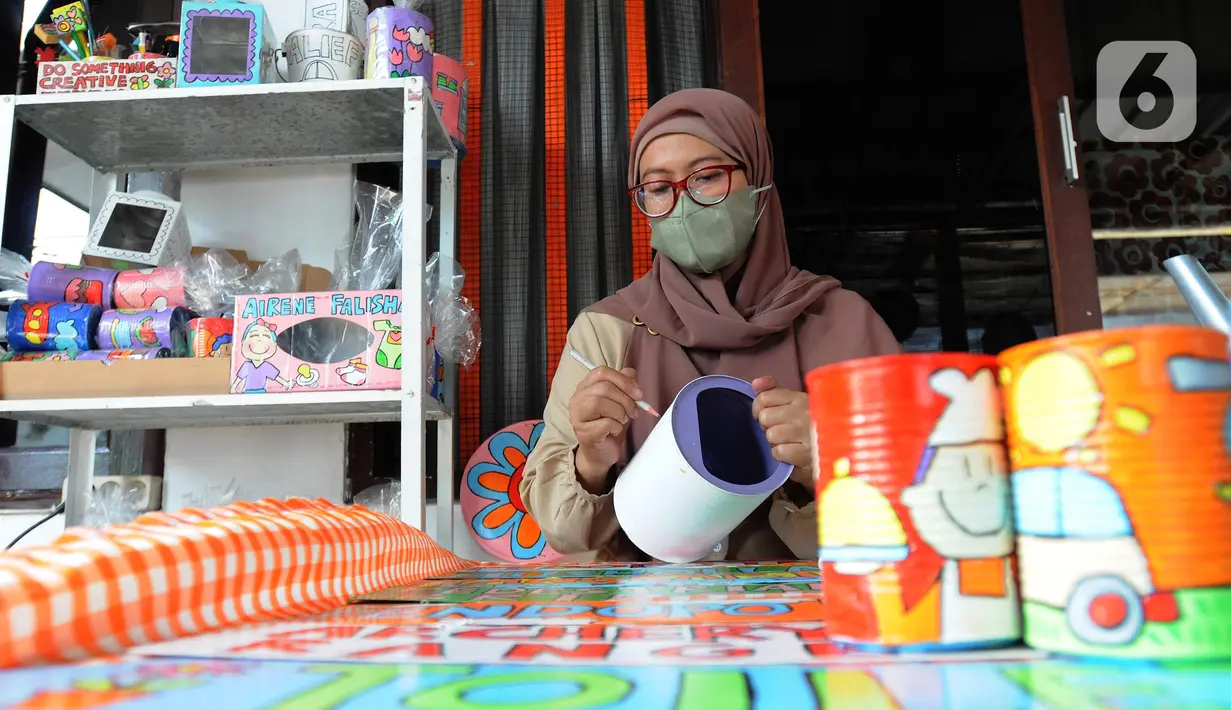 Perajin melukis bahan daur ulang untuk dipasarkan secara online di Kaleng Lani  di kawasan Tanah Baru, Depok, Jawa Barat, Rabu (9/3/2022). Setiap bulannya perajin mampu memberikan pendapatan ekonomi keluarga antara Rp 5 juta hingga Rp 7,5 juta. (merdeka.com/Arie Basuki)