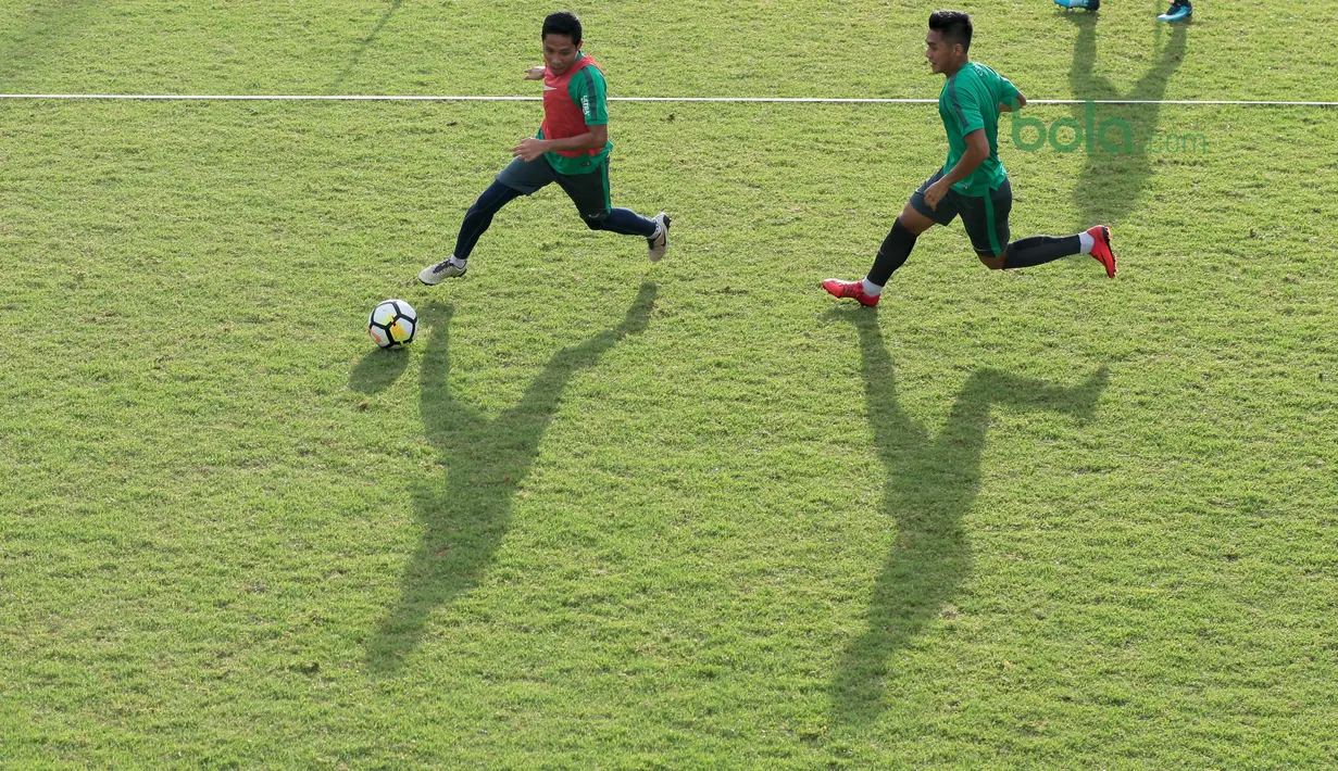 Evan Dimas (kiri) menggiring bola melewati Septian David saat berlatih di Lapangan ABC, Senayan,  (24/4/2018). Timnas akan mengikuti turnamen PSSI Anniversary 27 April-3 Mei 2018. (Bola.com/Nicklas Hanoatubun)