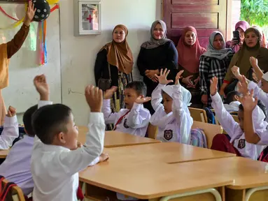 Orangtua siswa mengamati kelas pada hari pertama sekolah di sebuah sekolah dasar di Banda Aceh, Aceh, Senin (17/7/2023). (Chaideer MAHYUDDIN/AFP)