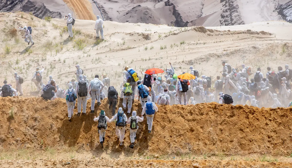 Aktivis iklim mamasuki tambang batu bara lignit Garzweiler di Garzweiler, Jerman barat, Sabtu (22/6/2019). Para aktivis mengenakan pakaian putih dan membawa kantong tidur. (Marcel Kusch/DPA/AFP)