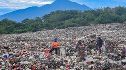 Warga yang berprofesi sebagai pemulung mengumpulkan sampah plastik dengan latar belakang Gunung Gede-Pangrango di Tempat Pembuangan Akhir Galuga, Bogor, Kamis (6/11/2025). Data Sistem Informasi Pengelolaan Sampah Nasional (SIPSN) menunjukkan bahwa jumlah sampah plastik menempati posisi kedua sebesar 19,52 persen dari total timbulan sampah nasional 34,9 juta ton yang dilaporkan pada 2024. (merdeka.com/Arie Basuki)
