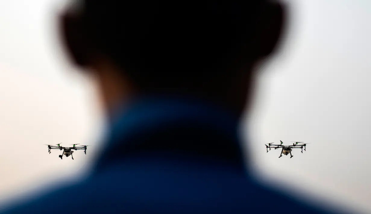 Relawan Administrasi Metropolitan Bangkok (BMA) menerbangkan drone untuk menurunkan hujan buatan pada demontrasi, Kamis (31/1). Thailand mengerahkan drone untuk menyemprotkan air dalam memerangi polusi udara di Ibu Kota yang makin parah. (Jewel SAMAD/AFP)