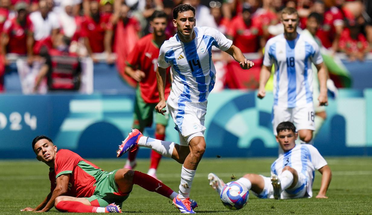 Pemain Argentina, Santiago Hezze, berusaha melewati pemain Maroko pada laga pertama grup B Olimpiade 2024 di stadion Geoffroy-Guichard, Rabu (24/7/2024). (AP Photo/Silvia Izquierdo)