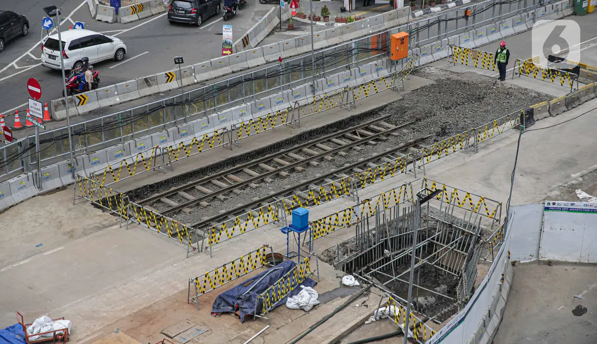 Petugas berjaga dekat lokasi ditemukannya rel trem di proyek pembangunan MRT Jakarta fase 2A paket kontrak atau CP 203 Glodok-Kota, Selasa (28/12/2021). Rel trem dari era kolonial Belanda tersebut ditemukan saat penggalian proyek MRT Fase 2A Glodok-Kota. (Liputan6.com/Faizal Fanani)