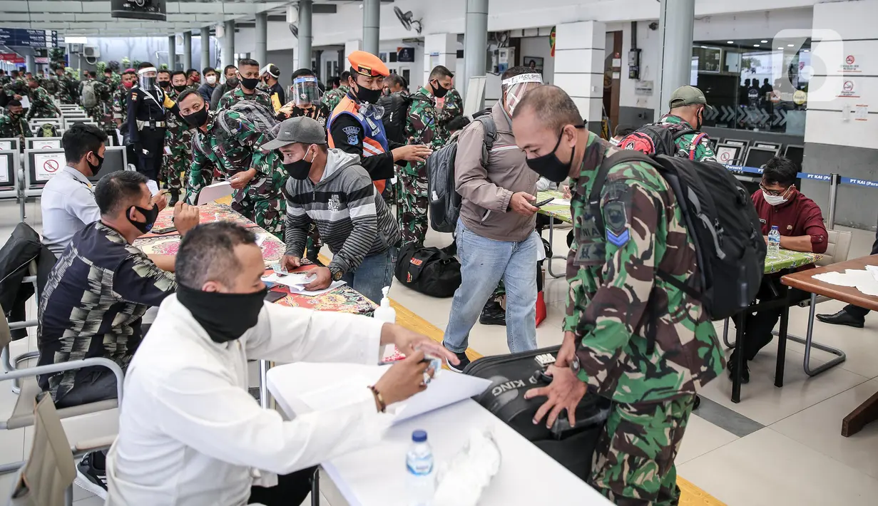 Calon penumpang melapor kepada petugas di Stasiun Pasar Senen, Jakarta, Jumat (10/7/2020). PT KAI telah mengoperasikan lima perjalanan kereta jarak jauh untuk tujuan Bandung, Cirebon, dan Surabaya mulai Jumat 10 Juli 2020. (Liputan6.com/Faizal Fanani)