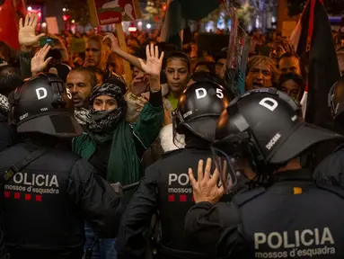 Petugas kepolisian bentrok dengan demonstran pro-Palestina saat mereka mencoba masuk ke stasiun kereta di Barcelona, Spanyol, Sabtu (11/11/2023). (AP Photo/Emilio Morenatti)