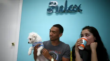 Pengunjung bermain bersama anak anjing saat mengunjungi Dog Cafe di Los Angeles, AS (7/4). Di kafe ini pengunjung dapat bermain dan mengadopsi anjing yang berada di kafe ini. (REUTERS/Lucy Nicholson)