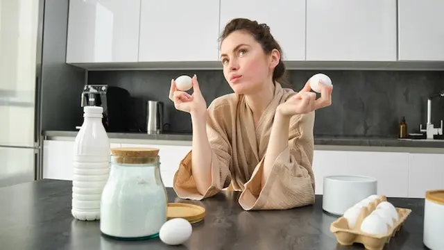 wanita dengan telur di dapur
