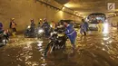 Pengendara mendorong motornya menerobos banjir di underpass Cawang, Jalan MT Haryono, Jakarta, Selasa (12/12). Hujan deras dan buruknya drainase di kawasan tersebut menjadi penyebab utama adanya genangan air hingga 50 cm. (Liputan6.com/Herman Zakharia)