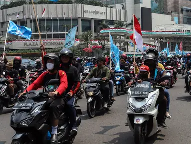 Buruh melakukan konvoi menggunakan sepeda motor di Bundaran Hotel Indonesia untuk mengikuti unjuk rasa di depan Gedung DPR, Jakarta, Rabu (10/8/2022). Dalam aksi tersebut mereka menuntut agar pemerintah menghapus Omnibus Law. (Liputan6.com/Johan Tallo)