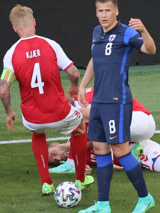 Gelandang Finlandia, Robin Lod (kanan) memberi isyarat kepada paramedis saat bek Denmark, Simon Kjaer (kiri) berlari ke arah rekan setimnya, Christian Eriksen yang pingsan di lapangan pada laga Denmark vs Finlandia di Grup B Euro 2020 di Parken Stadium, Sabtu (12/6/2021). (WOLFGANG RATTAY/POOL/AFP)
