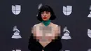 Penyanyi Chile Mon Laferte membuka bajunya saat berpose di karpet merah Latin Grammy Awards 2019, MGM Grand Garden Arena, Las Vegas, Amerika Serikat, Kamis (14/11/2019). Aksi mon juga sebagai bentuk dukungan bagi demonstran antipemerintah di Chile. (Bridget BENNETT/AFP)