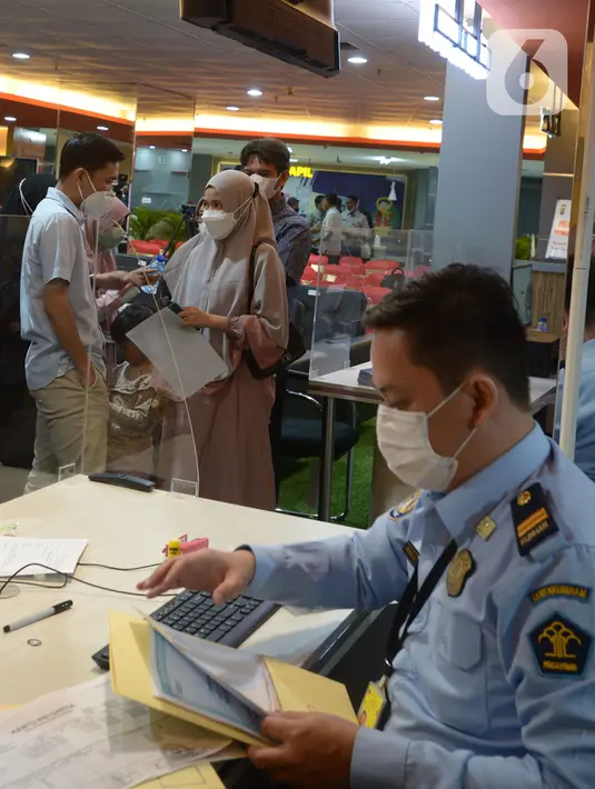 Petugas mengecek data paspor di PGC, Jakarta, Jumat (1/4/2022). Gerai pelayanan paspor imigrasi yang ada di Mal dan Pusat Grosir Cililitan untuk meningkatkan pelayanan publik agar tidak mengantre berjam-jam untuk membuat paspor baru dan memperpanjang masa aktif paspor. (merdeka.com/Imam Buhori)