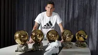 Bintang Barcelona, Lionel Messi, berpose dengan lima trofi Ballon d'Or dan sepatu khusus buatan Adidas. (Skysports). 