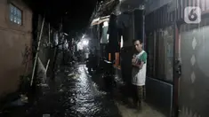 Warga berada di depan rumah saat banjir di kawasan Cipinang, Jakarta Timur, Minggu (23/2/2020) dini hari. Hujan deras yang mengguyur Jakarta dan sekitarnya sejak Sabtu malam ditambah buruknya drainase menyebabkan ratusan rumah di Cipinang terendam banjir. (merdeka.com/Iqbal S. Nugroho)
