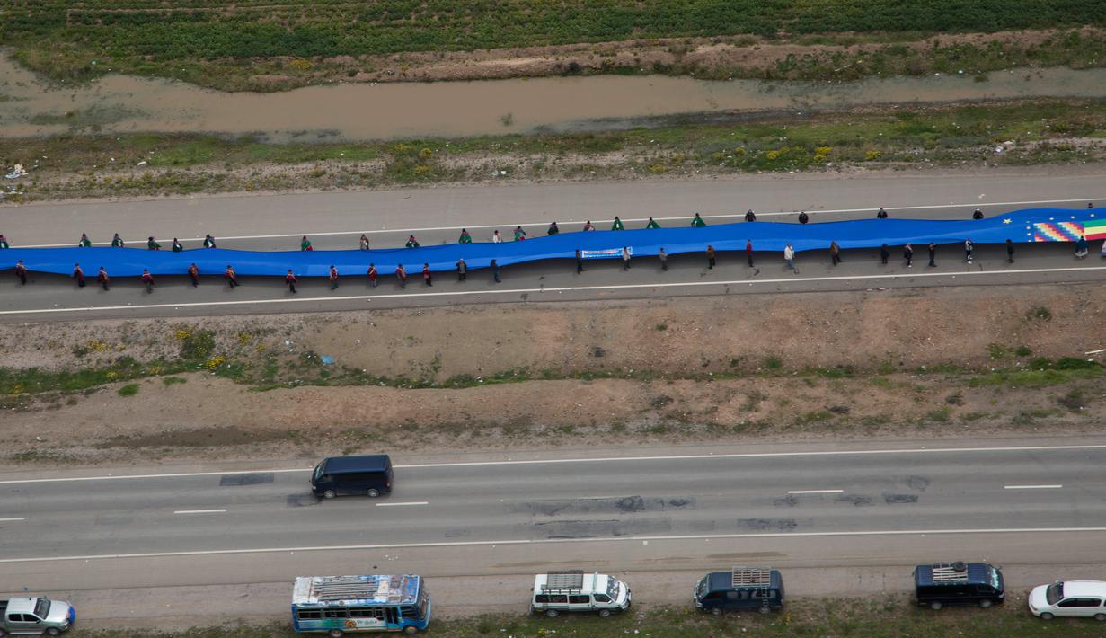 Bendera biru raksasa dibentangkan warga Bolivia di jalan raya antara Oruro dan La Paz Bolivia (10/3). Puluhan ribu warga Bolivia memegang bendera untuk memperoleh hak ke laut. (AP Photo / Juan Karita)