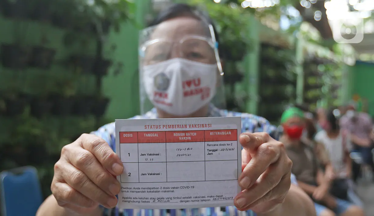 Warga lanjut usia (lansia) menunjukkan kartu vaksinasi Covid-19 di Puskesmas Kecamatan Senen, Jakarta Pusat, Selasa (23/2/2021). Vaksinasi untuk Lansia akan dimulai di ibu kota provinsi untuk seluruh provinsi di Indonesia, di prioritaskan di Jawa-Bali. (Liputan6.com/Herman Zakharia)