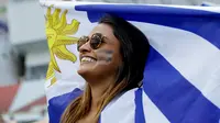 Suporter wanita Uruguay membentangkan bendera negaranya sebelum pertandingan antara Uruguay melawan Portugal pada 16 besar Piala Dunia 2018 di Stadion Fisht di Sochi, Rusia, (30/6). Uruguay berhasil mengalahkan Portugal 2-1. (AP Photo/Andre Penner)
