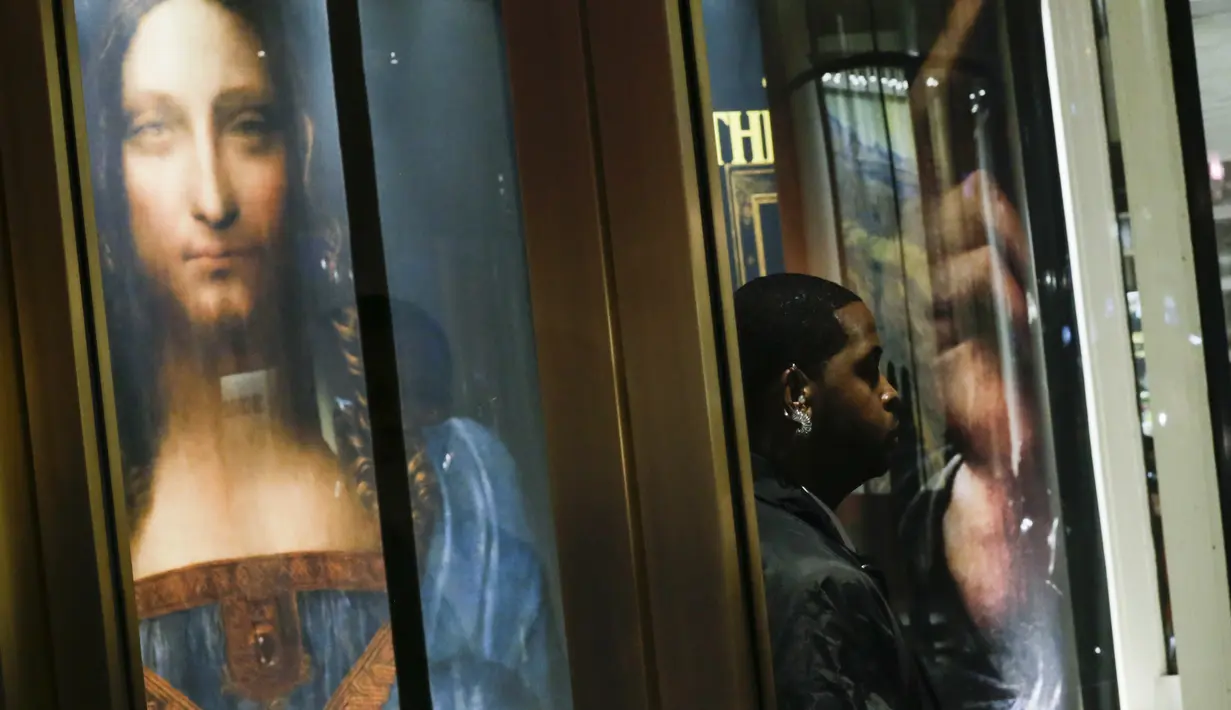 Poster bergambar lukisan karya Leonardo da Vinci yang dipajang saat pelelangan di Christie's New York Auction House, New York City (15/11). Harga itu mencetak rekor sebagai karya seni termahal yang pernah dilelang. (Drew Angerer/Getty Images/AFP)