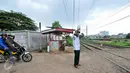 Akibat tidak adanya penjaga perlintasan kereta api, Muhamad Ali warga Pondok Cina berinisiatif untuk mejaga pos jaga perlintasan kereta api yang dibuat secara swadaya, Depok, Minggu (13/12/2015). (Liputan6.com/Yoppy Renato)