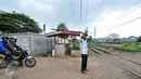 Akibat tidak adanya penjaga perlintasan kereta api, Muhamad Ali warga Pondok Cina berinisiatif untuk mejaga pos jaga perlintasan kereta api yang dibuat secara swadaya, Depok, Minggu (13/12/2015). (Liputan6.com/Yoppy Renato)