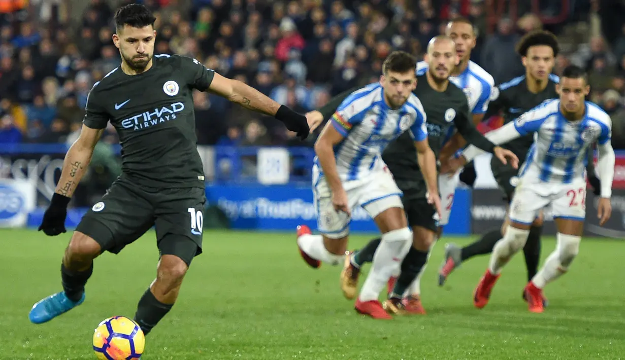Penyerang Manchester City, Sergio Aguero (kiri) mencetak satu gol lewati titik putih saat melawan Huddersfield Town pada laga Premier League di John Smith's stadium, Huddersfield, (26/11/2017).  City menang 2-1. (AFP/Oli Scarff)